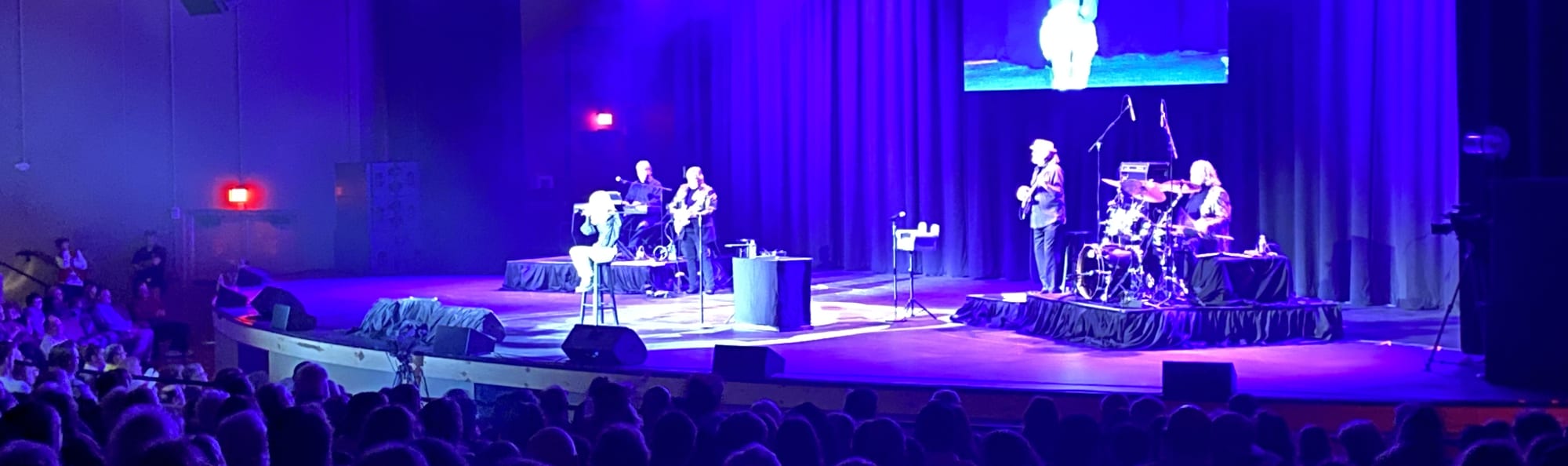 signer on stage in chair washed out by the lights Provo